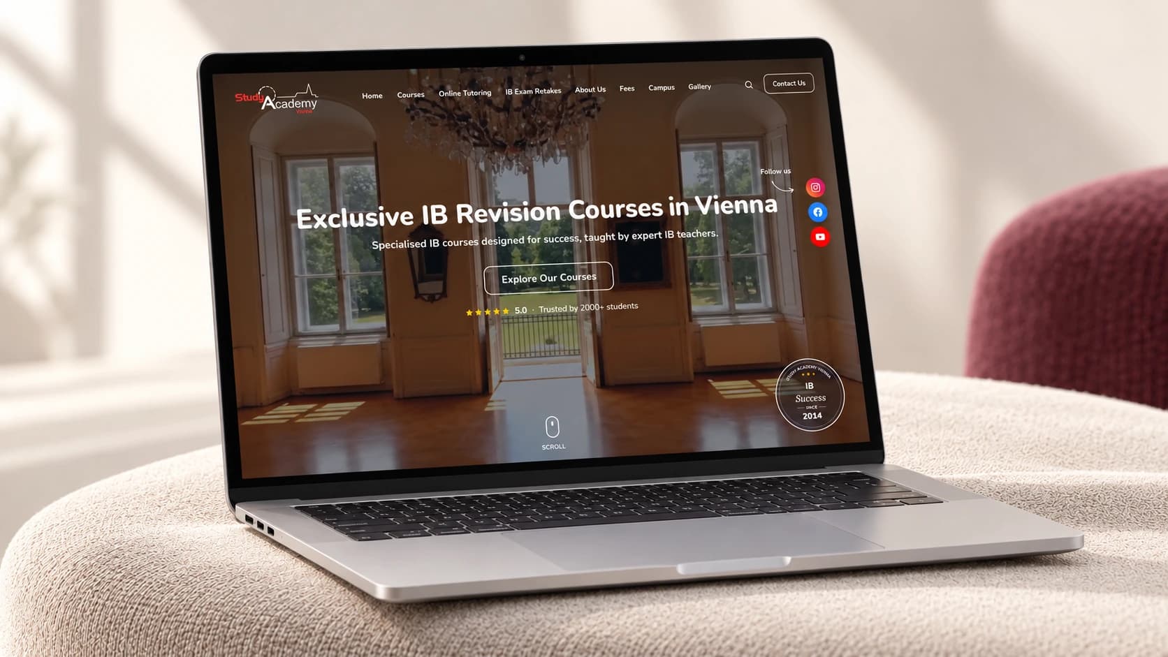 Study Academy Vienna homepage displayed on a laptop on an upholstered bench