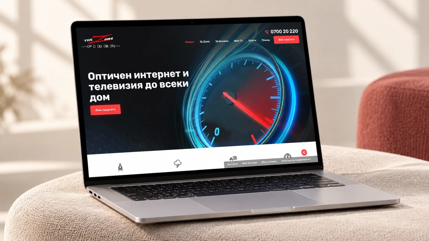The Zone homepage displayed on a laptop on an upholstered bench